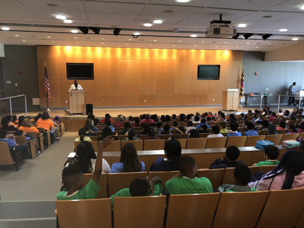TGN speaker presenting to a full auditorium of students at a community workshop
